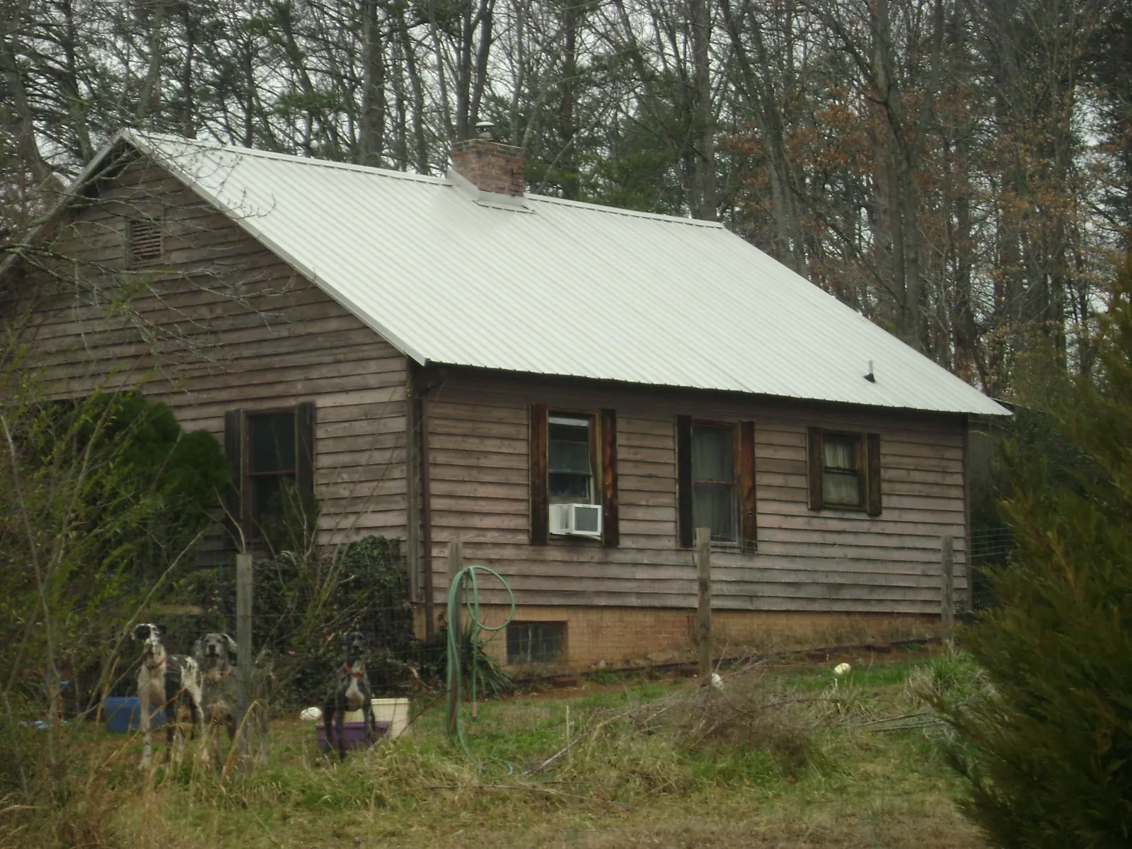 White metal roof on an old wood sided farmhouse, from a Metal Roof Installation job in Baldwin